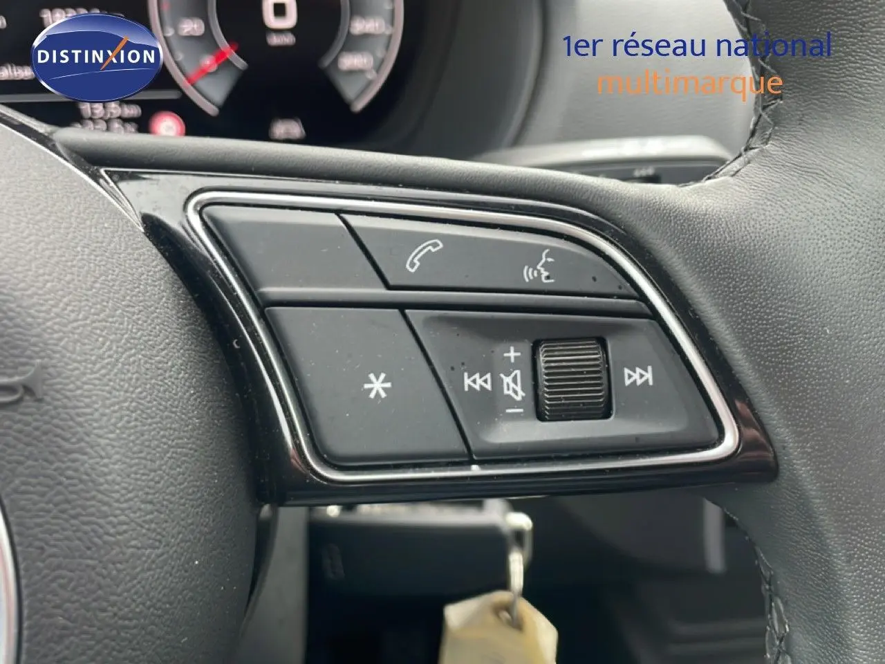 Gros plan sur les commandes multimédia au volant cuir noir de l'Audi Q2 30 TDI S-Line 2025.