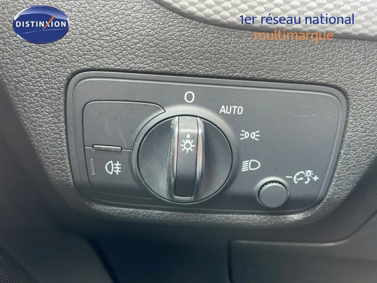 Détail du bouton de commande des phares sur le tableau de bord d’un Audi Q2 noir mito metal 2025.