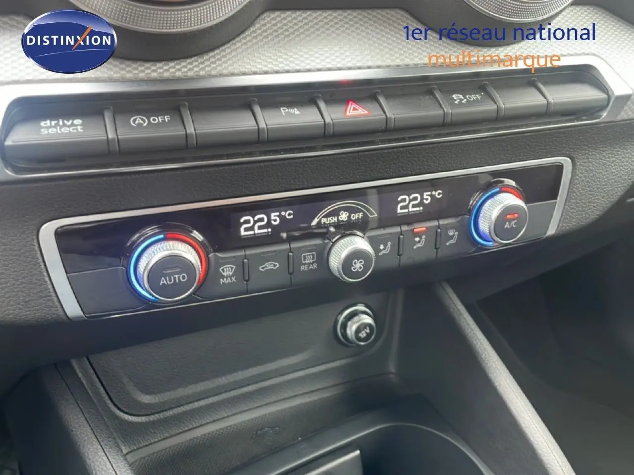 Vue rapprochée du tableau de bord de l'Audi Q2 30 TDI S-Line 2025, montrant les commandes de climatisation digitale et boutons fonctionnels.