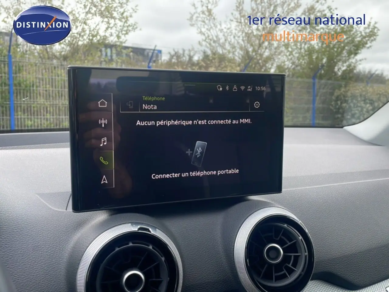 Écran tactile central avec interface MMI affichant la connexion Bluetooth, entouré de deux aérateurs ronds dans l’habitacle d’un Audi Q2 noir.