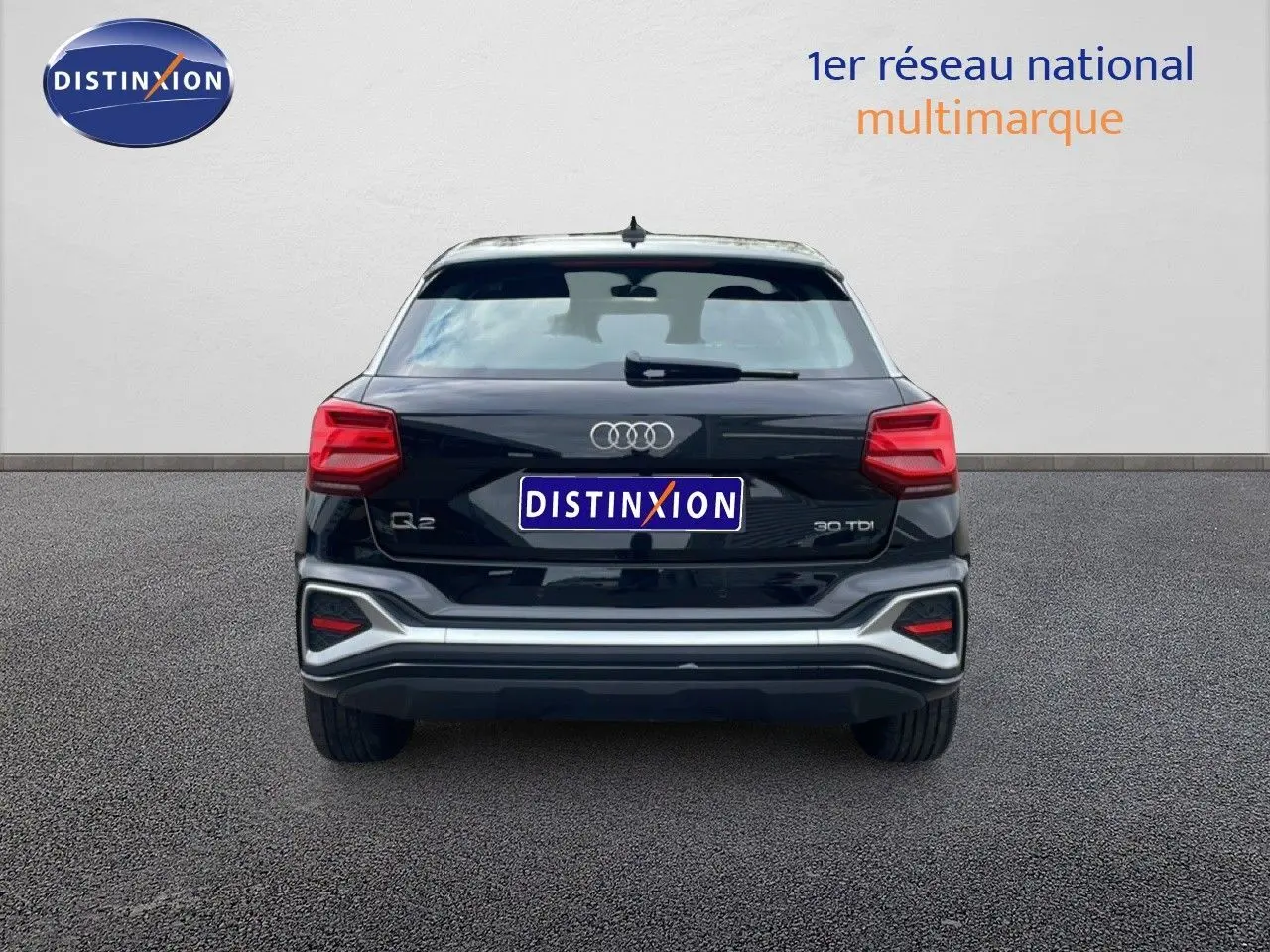 Vue arrière d’un Audi Q2 30 TDI S-Line noir mito metal avec feux rouges et détails argentés sur le pare-chocs.