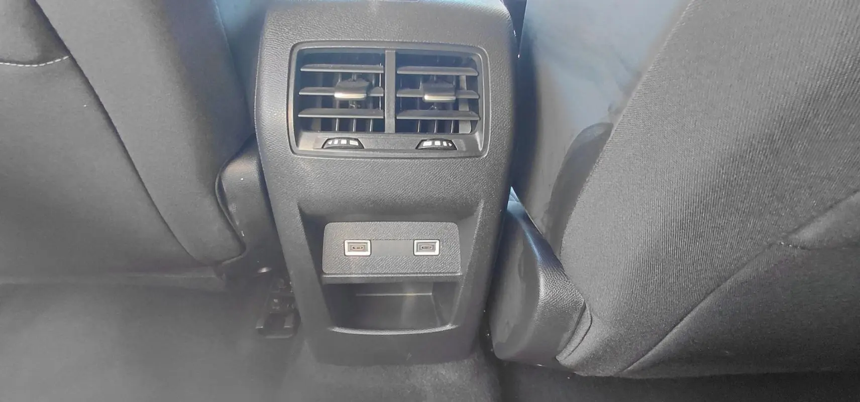 Vue rapprochée des aérateurs arrière et des deux ports USB situés entre les sièges arrière d'une Peugeot 308 gris 2025.