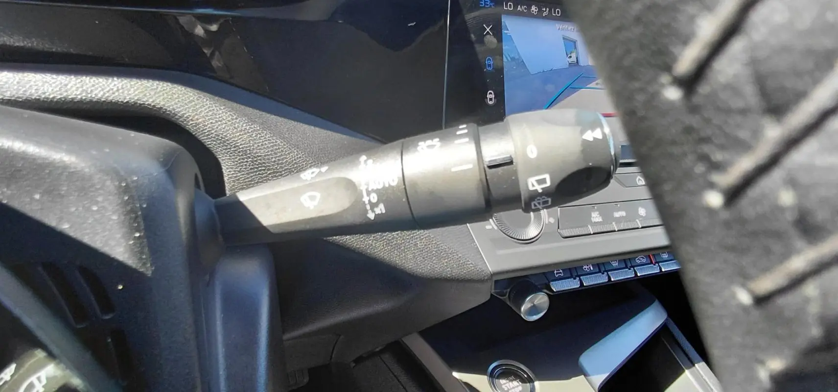 Gros plan sur la commande d’essuie-glace à gauche du volant dans l’habitacle gris du Peugeot 308 2025.