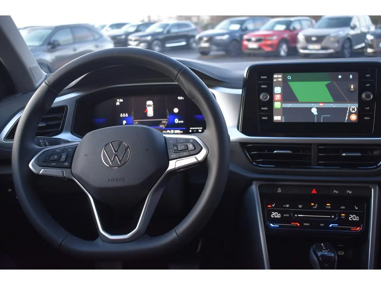 Vue intérieure centrée sur le volant multifonction et l'écran tactile du Volkswagen T-Roc 2025, tableau de bord moderne.