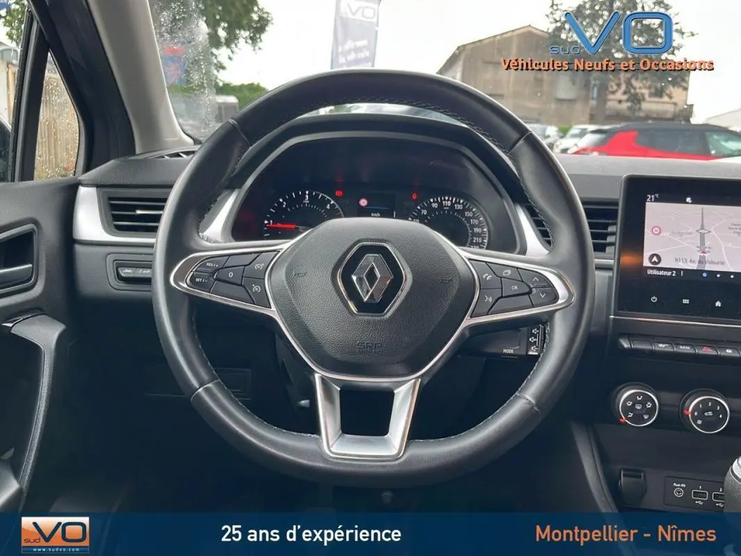 Vue centrée sur le volant du Renault Captur gris 2021, avec tableau de bord et écran tactile visibles.