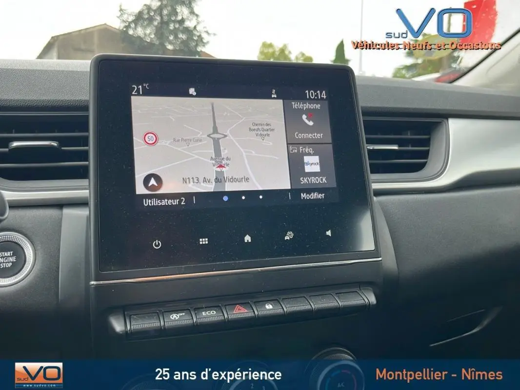Tableau de bord du Renault Captur gris 2021 avec écran tactile affichant la navigation et commandes intégrées.