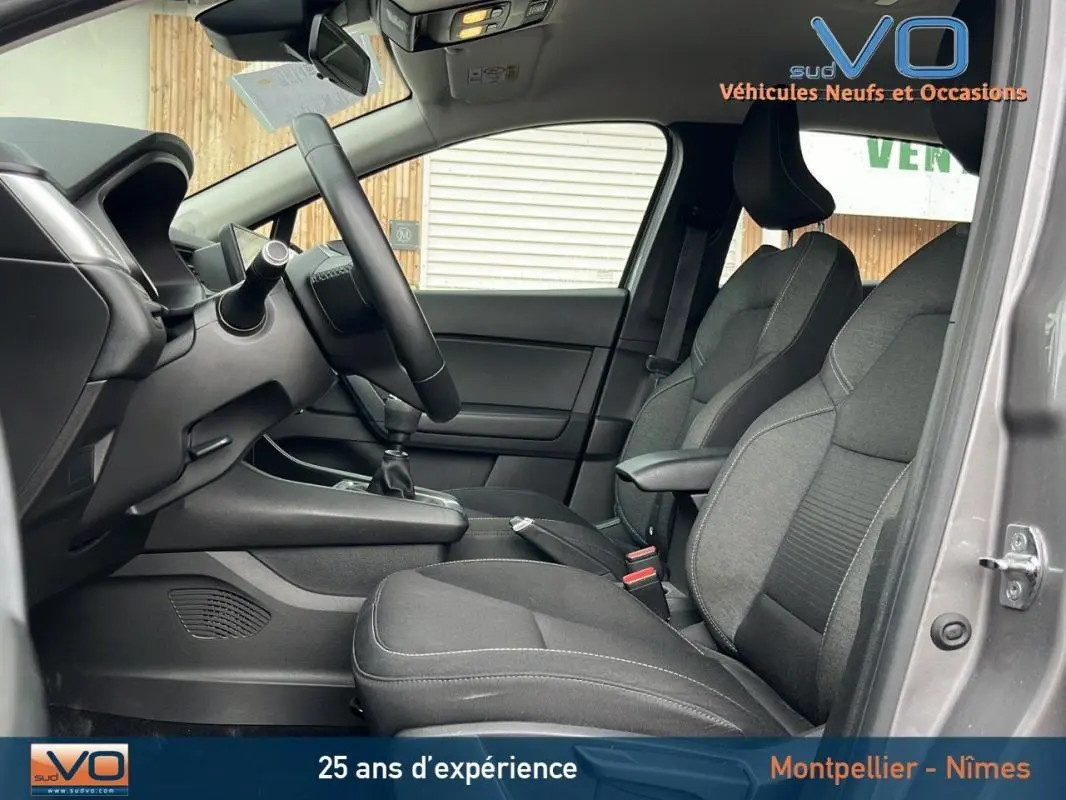 Intérieur avant du Renault Captur gris 2021, montrant les sièges tissu et la boîte manuelle côté conducteur.