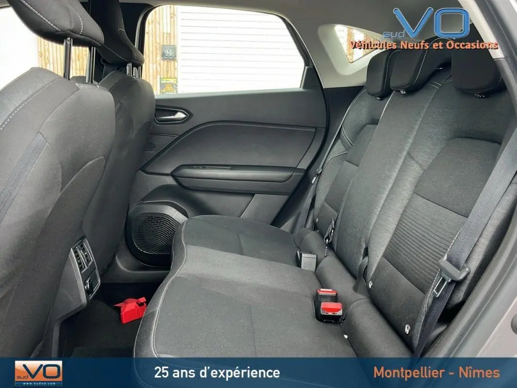 Vue latérale droite de l'intérieur arrière du Renault Captur gris 2021, montrant les sièges en tissu et les ceintures de sécurité.