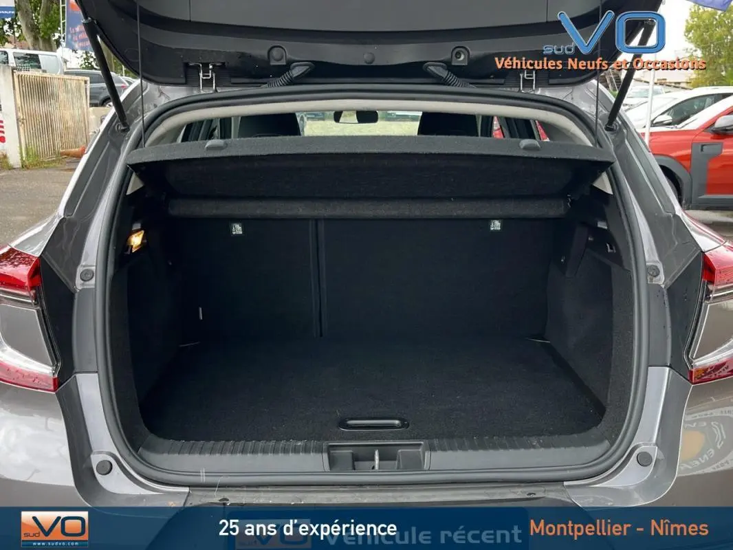 Coffre ouvert d'un Renault Captur gris 2021, vue arrière montrant l'espace de chargement vide et la tablette cache-bagages.