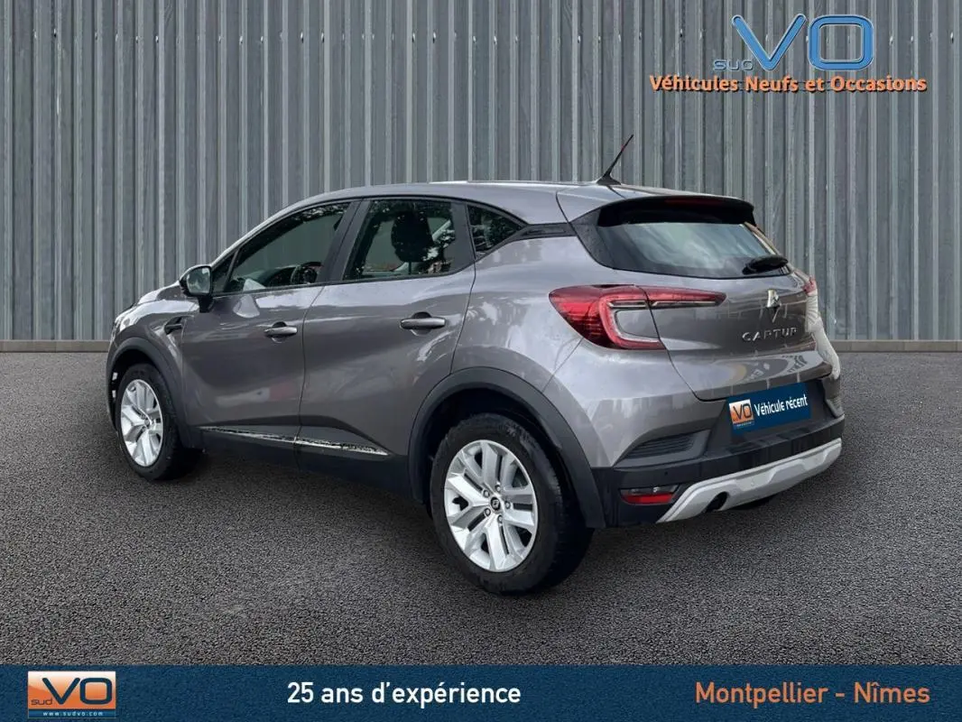 Vue 3/4 arrière droite d'un Renault Captur gris 2021, avec jantes argentées et feux arrière LED distinctifs.