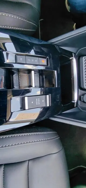 Vue rapprochée de la console centrale noire du Citroën C4 X hybride 2025 avec commandes de boîte auto et mode de conduite.