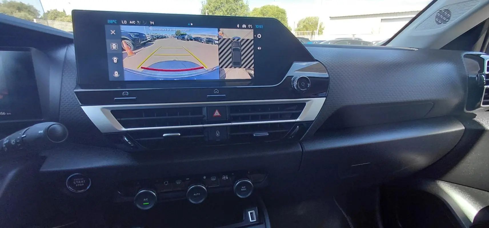 Vue intérieure du tableau de bord de la Citroën C4 X hybride noire 2025, avec écran tactile et commandes climatisation.