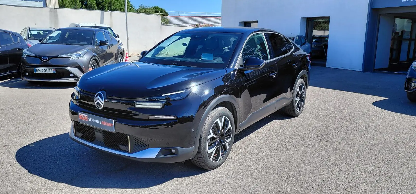 Citroën C4 X hybride noir vue 3/4 avant droit, avec jantes alliage 17 pouces et toit ouvrant panoramique.