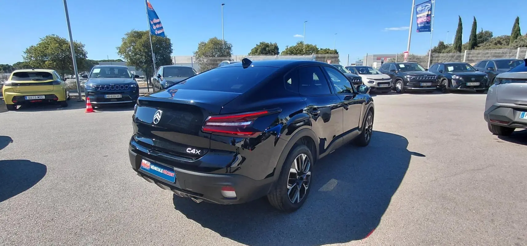 Vue 3/4 arrière droite d'une Citroën C4 X noire 2025 avec jantes alliage 17 pouces et toit ouvrant panoramique.