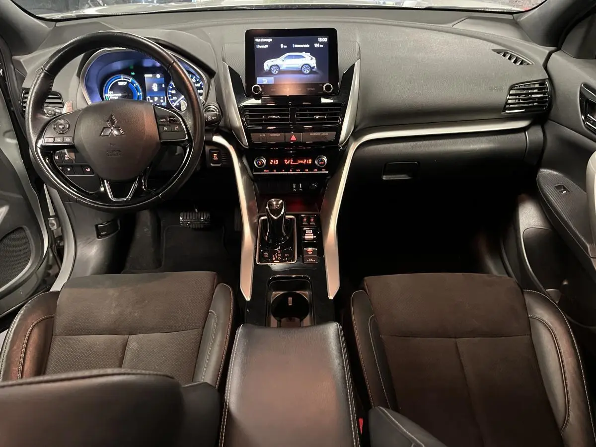 Vue intérieure avant du Mitsubishi Eclipse Cross gris, avec tableau de bord moderne et écran tactile central.