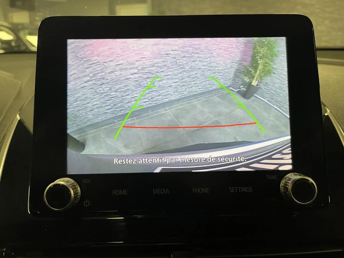 Écran multimédia montrant la caméra de recul du Mitsubishi Eclipse Cross 2022 avec lignes de guidage vertes et rouges.