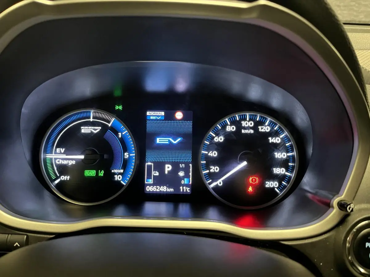 Tableau de bord du Mitsubishi Eclipse Cross hybride, affichage numérique EV et compteur analogique de vitesse jusqu'à 200 km/h.