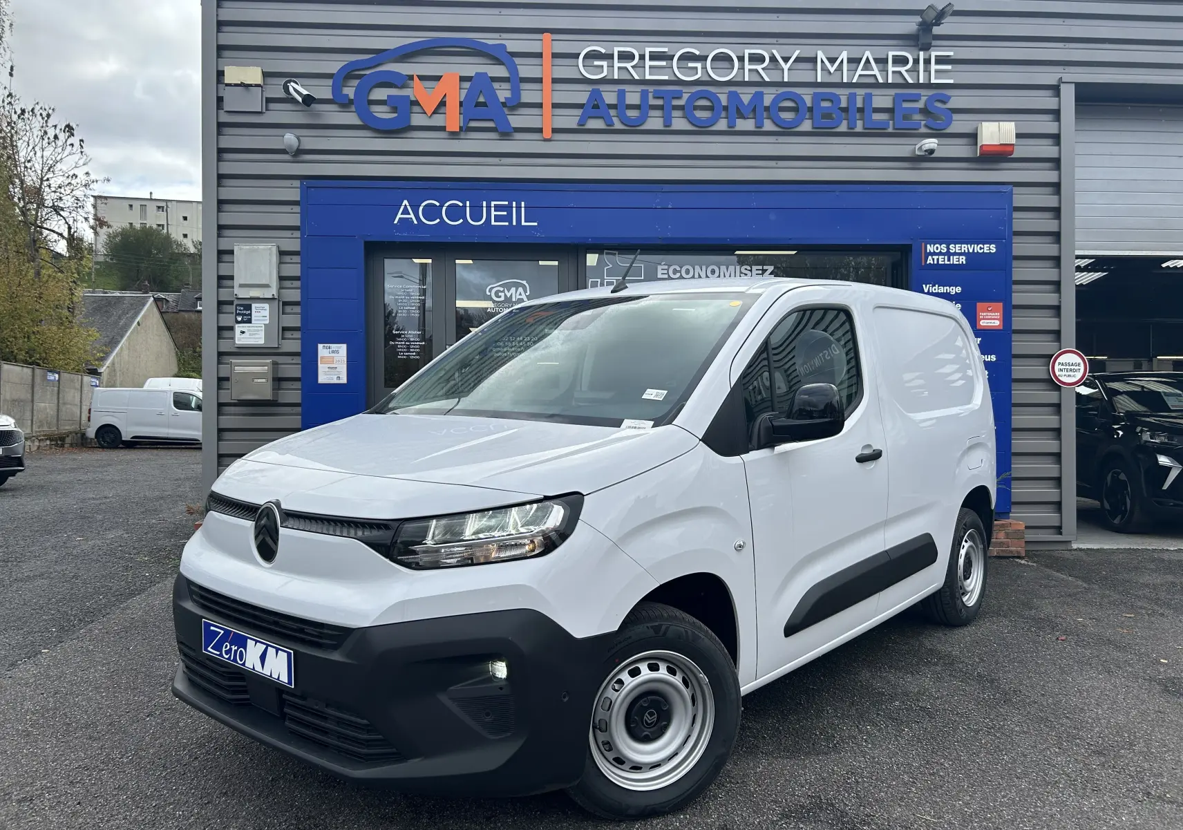Vue 3/4 avant d’un Citroën Berlingo Fourgon blanc stationné devant un garage Gregory Marie Automobiles.