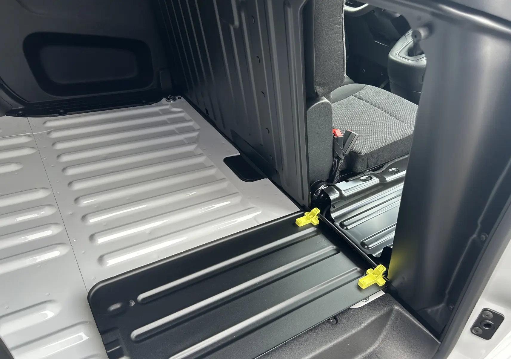 Vue intérieure du plancher arrière blanc et siège avant gris du Citroën Berlingo Fourgon BlueHDi 100 2025.