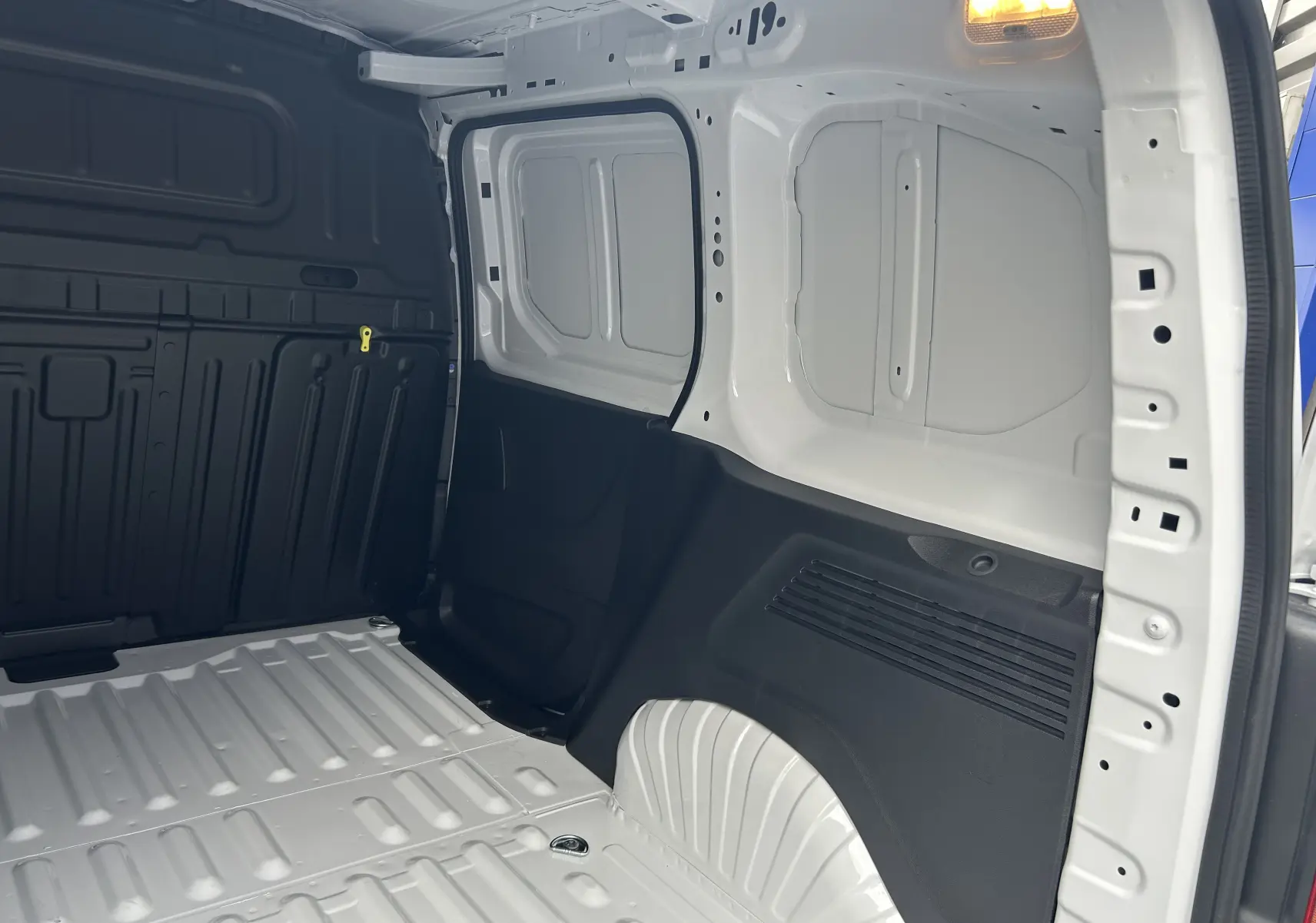 Intérieur du coffre blanc du Citroën Berlingo Fourgon 2025, vue latérale droite montrant la paroi et le plancher métalliques.