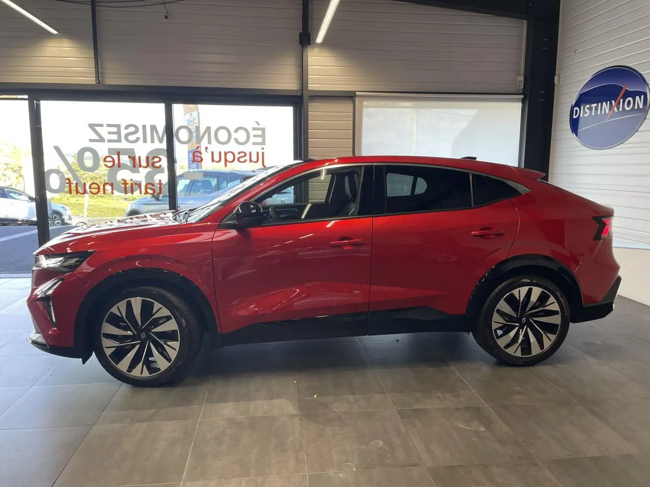 Profil côté gauche du Renault Rafale 2025 rouge flamme avec toit noir et jantes alliage noires et argentées.