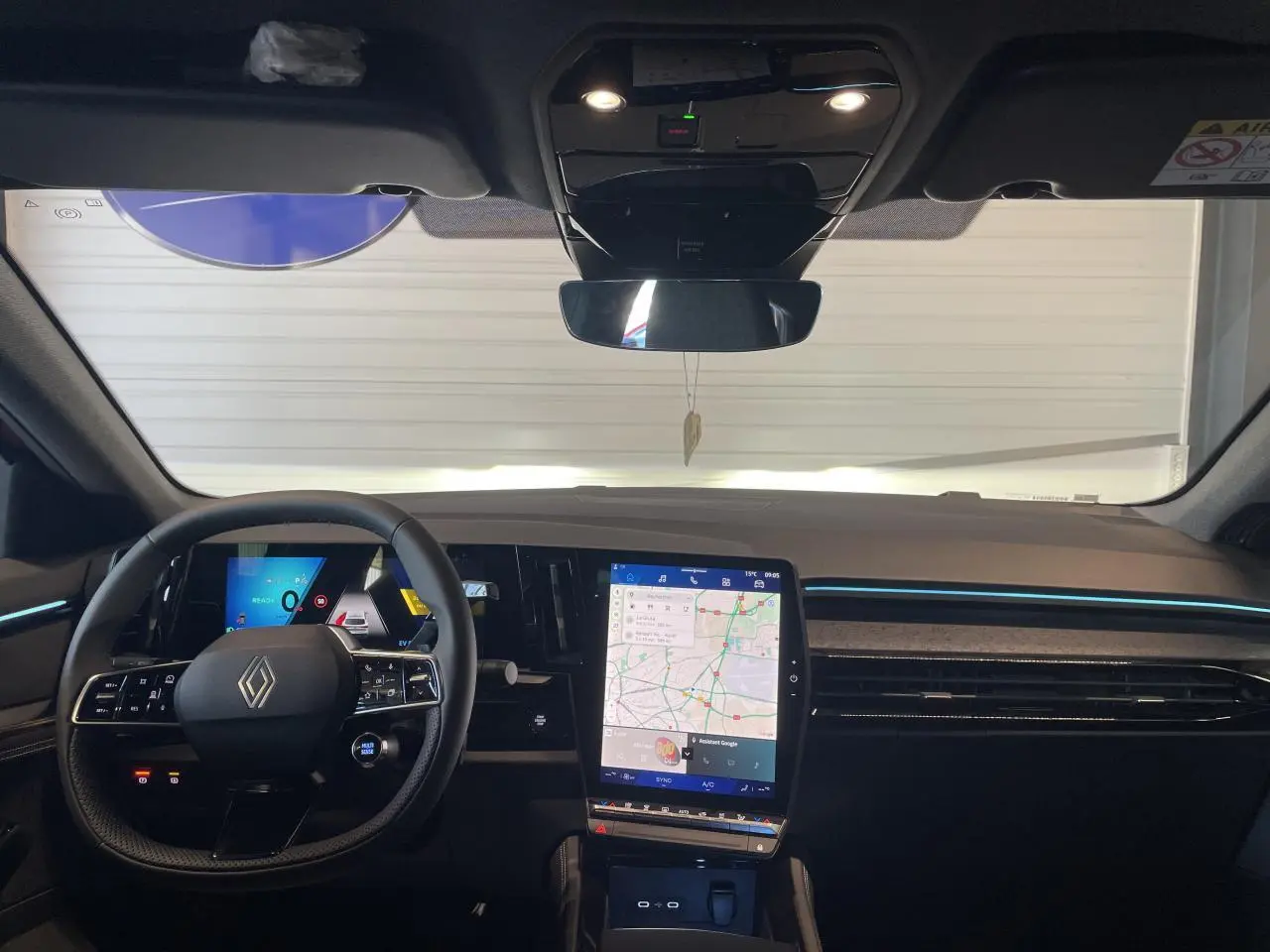 Vue frontale de l'intérieur du Renault Rafale 2025, tableau de bord noir avec écran tactile vertical et volant multifonction.