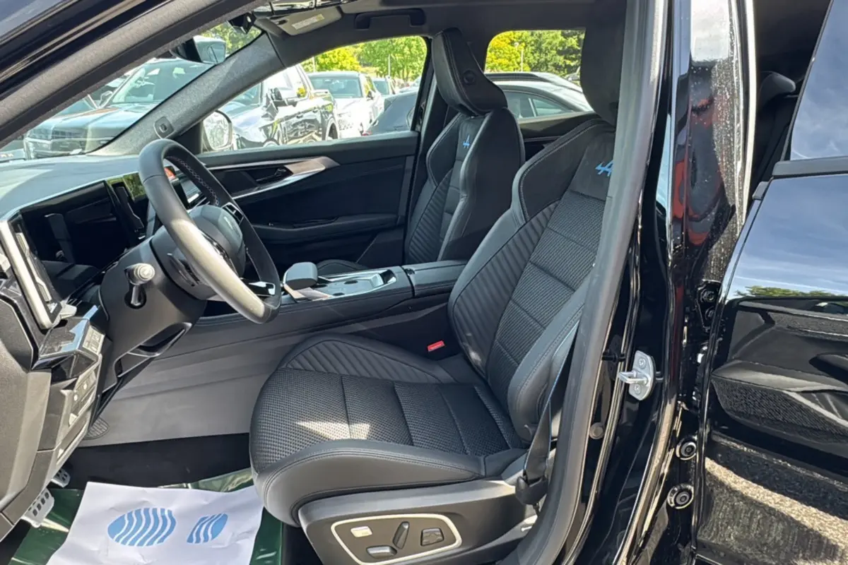 Vue intérieure côté conducteur du Renault Austral noir étoilé, sièges sport semi-alcantara avec logo Alpine bleu brodé.