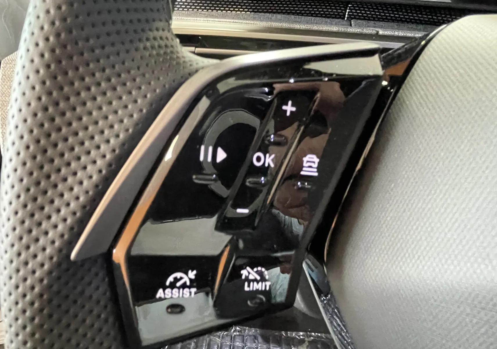 Gros plan sur les commandes noires du volant côté gauche du Peugeot 3008 Hybrid 145 e-DCS6 blanc et noir.