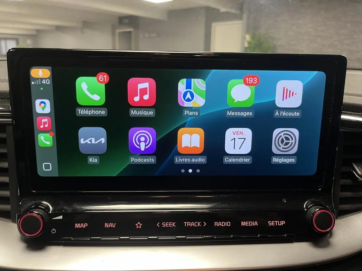Écran tactile central 10,25" de la Kia Ceed 2023 affichant Apple CarPlay avec commandes sous l'écran noir laqué.