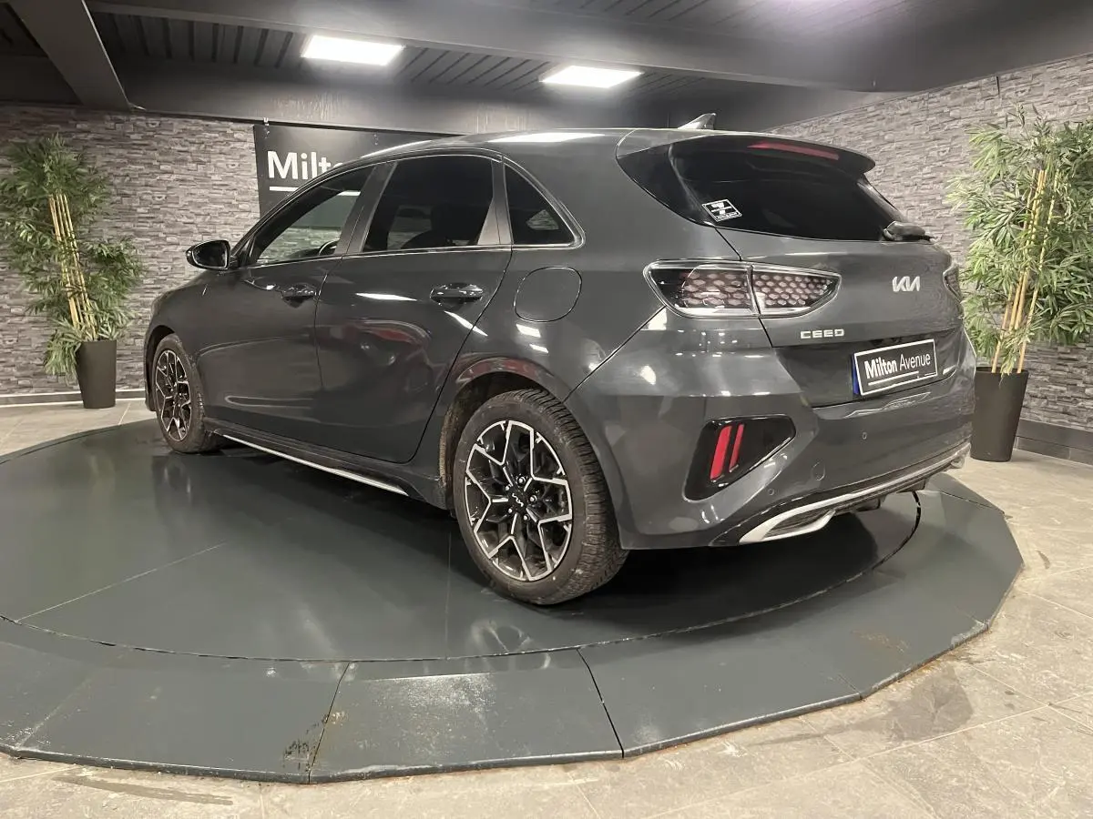 Vue 3/4 arrière droite d'une KIA Ceed gris métallisé avec jantes alliage et feux arrière en nid d'abeille.