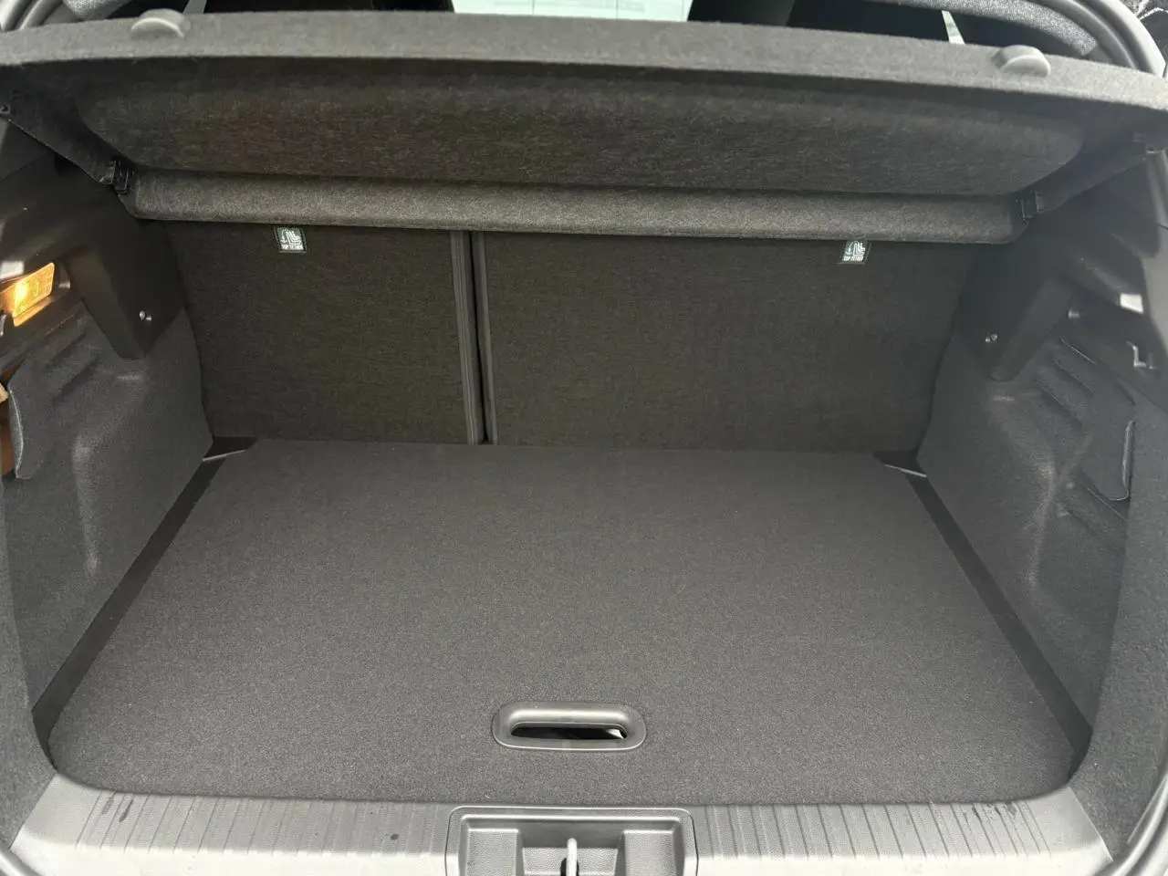 Vue intérieure du coffre spacieux et propre du Renault Captur 2025, avec plancher de coffre mobile et éclairage latéral.