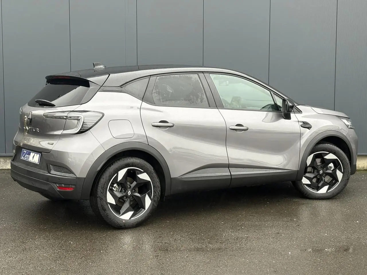 Vue latérale droite d'un Renault Captur 2025 gris Cassiopée avec toit noir étoilé et jantes aluminium 18 pouces.