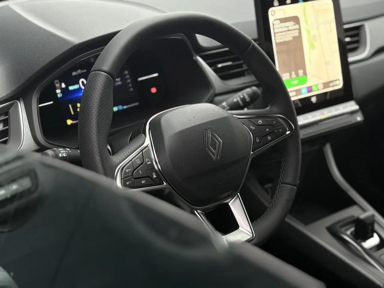 Vue rapprochée du volant noir et du tableau de bord numérique du Renault Captur 2025 avec écran tactile vertical.