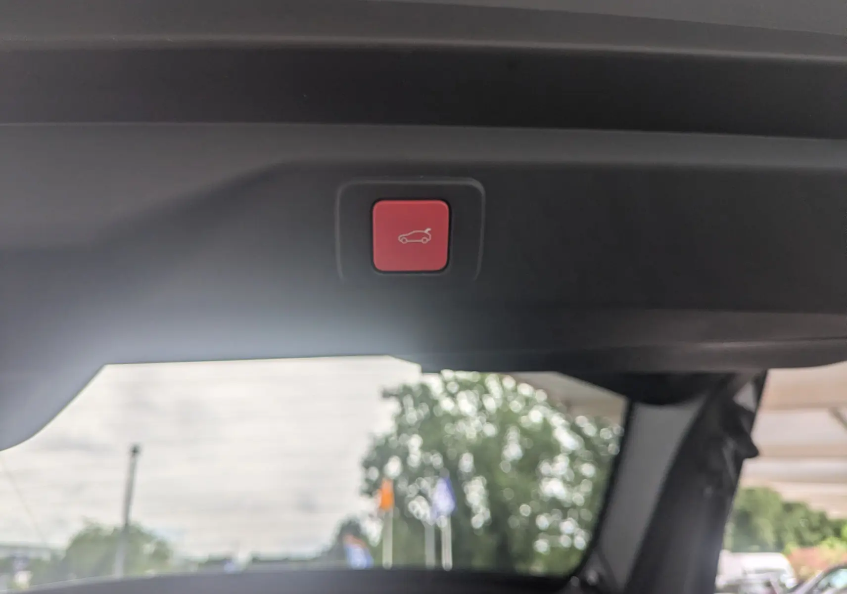 Bouton rouge de fermeture électrique du hayon vu de l'intérieur arrière du Peugeot 3008 Hybrid 145 GT Exclusive 2026.