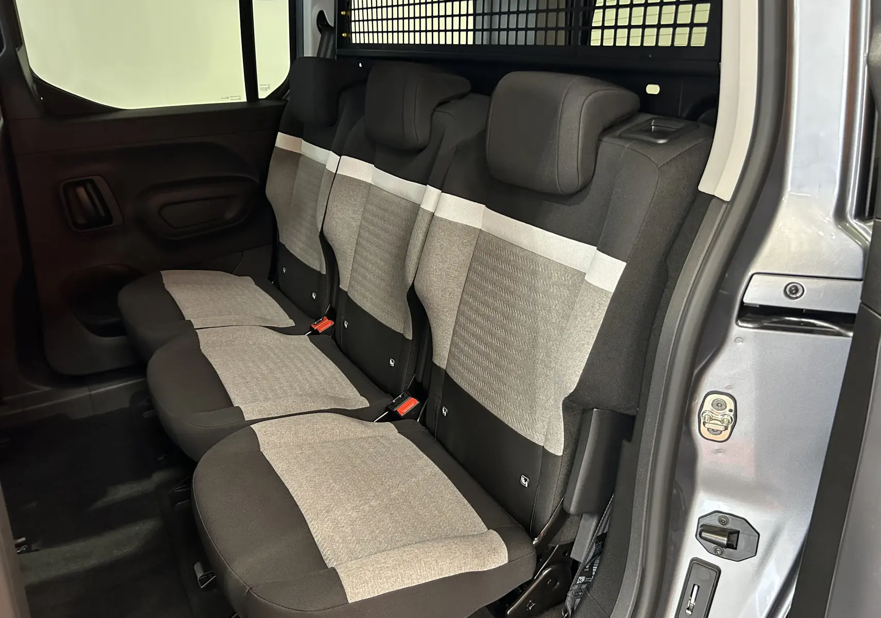 Vue intérieure côté droit sur la banquette arrière trois places en tissu gris et noir du Citroën Berlingo Multispace gris acier.