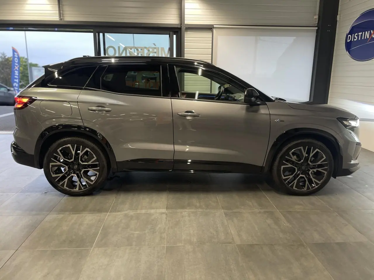 Profil droit du Renault Austral 2025 gris schiste métallisé avec toit noir étoilé et jantes noires distinctives.