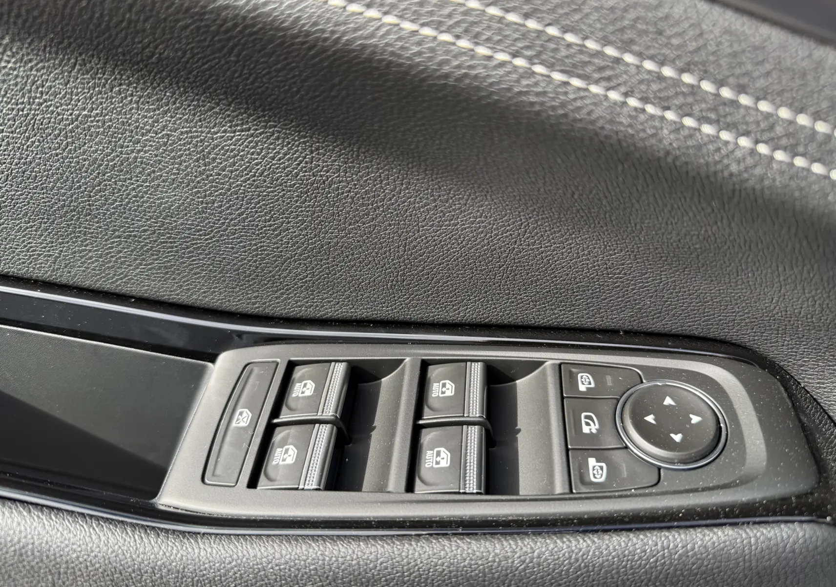 Détail des commandes intérieures noires du Renault Austral Full Hybrid, avec boutons de verrouillage et assistance au stationnement.