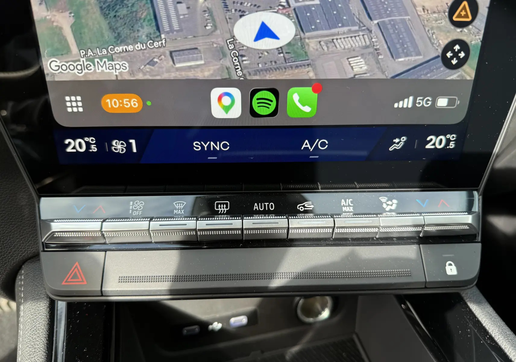 Vue rapprochée de la console centrale noire étoile du Renault Austral 2026 avec chargeur sans fil et clé dans un sachet plastique.