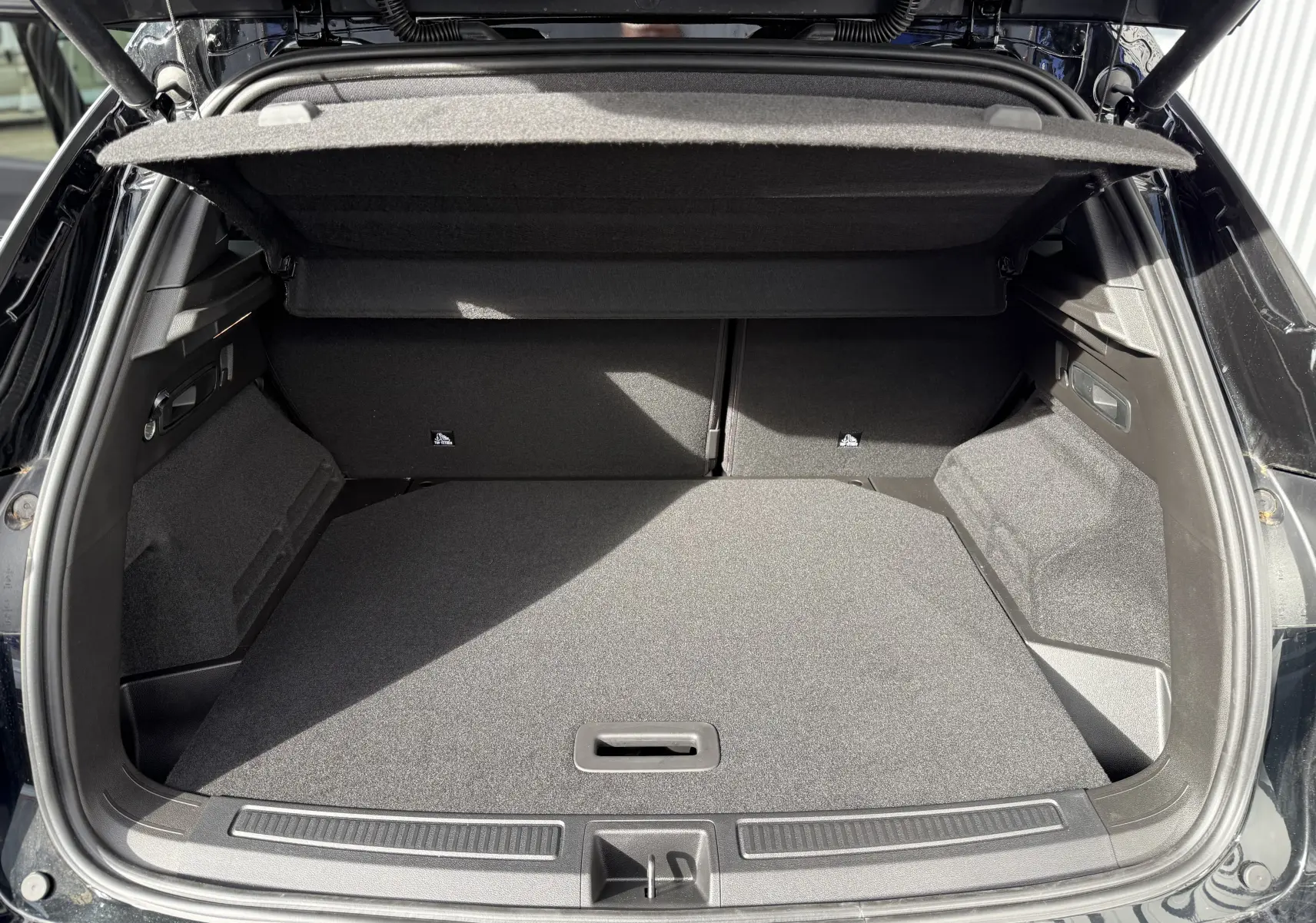 Gros plan sur la roue de secours noire étoile du coffre du Renault Austral Full Hybrid 2026.