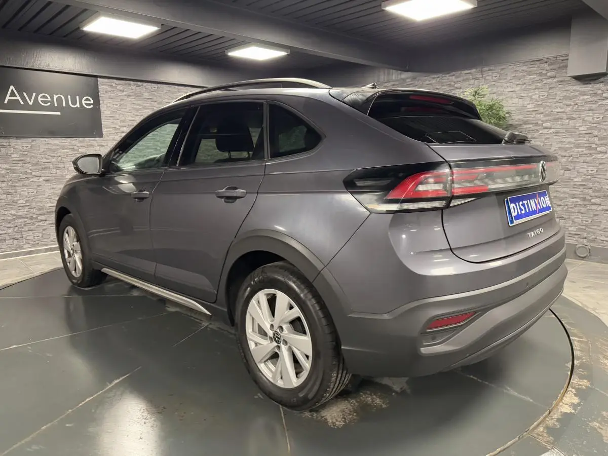 Volkswagen Taigo gris en 3/4 arrière droit, avec jantes alliage Belmopan et feux arrière LED allumés.