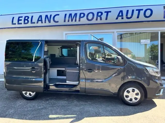 Profil droit du Renault Trafic Fourgon gris comète avec porte coulissante ouverte dévoilant l'aménagement intérieur van.