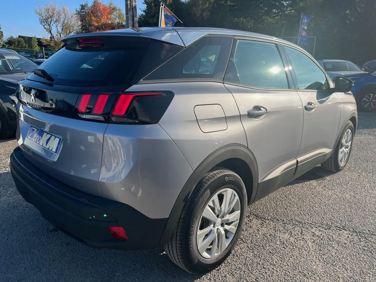 Vue 3/4 arrière droite d'un Peugeot 3008 gris Artense 2023 avec feux arrière LED et jantes alliage 17 pouces.