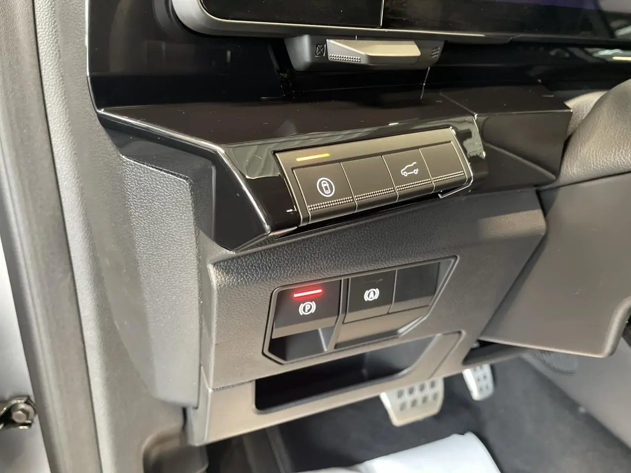 Gros plan sur les commandes du frein de parking électrique et ouverture du hayon dans l'habitacle du Renault Austral 2025.