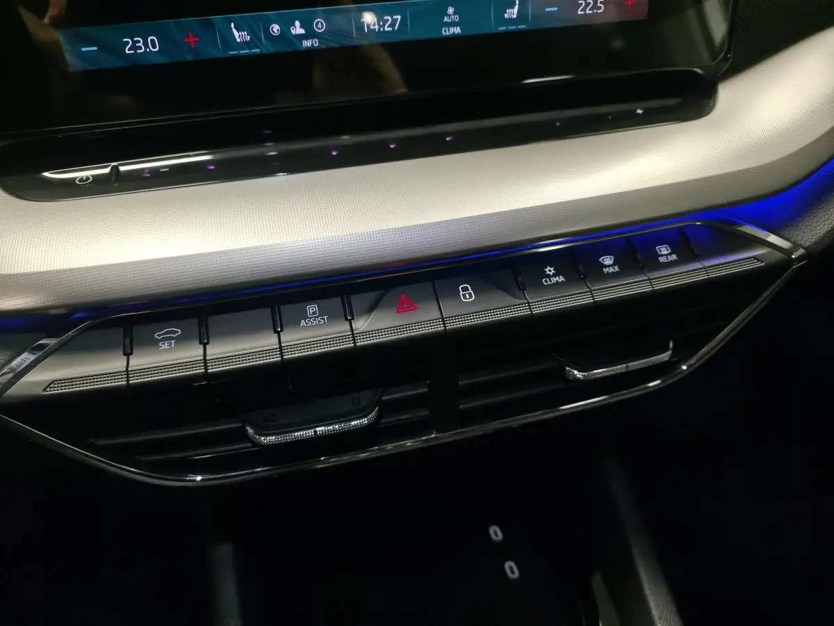Gros plan sur la console centrale de la Skoda Octavia 2023 avec boutons de commande et éclairage d'ambiance bleu.