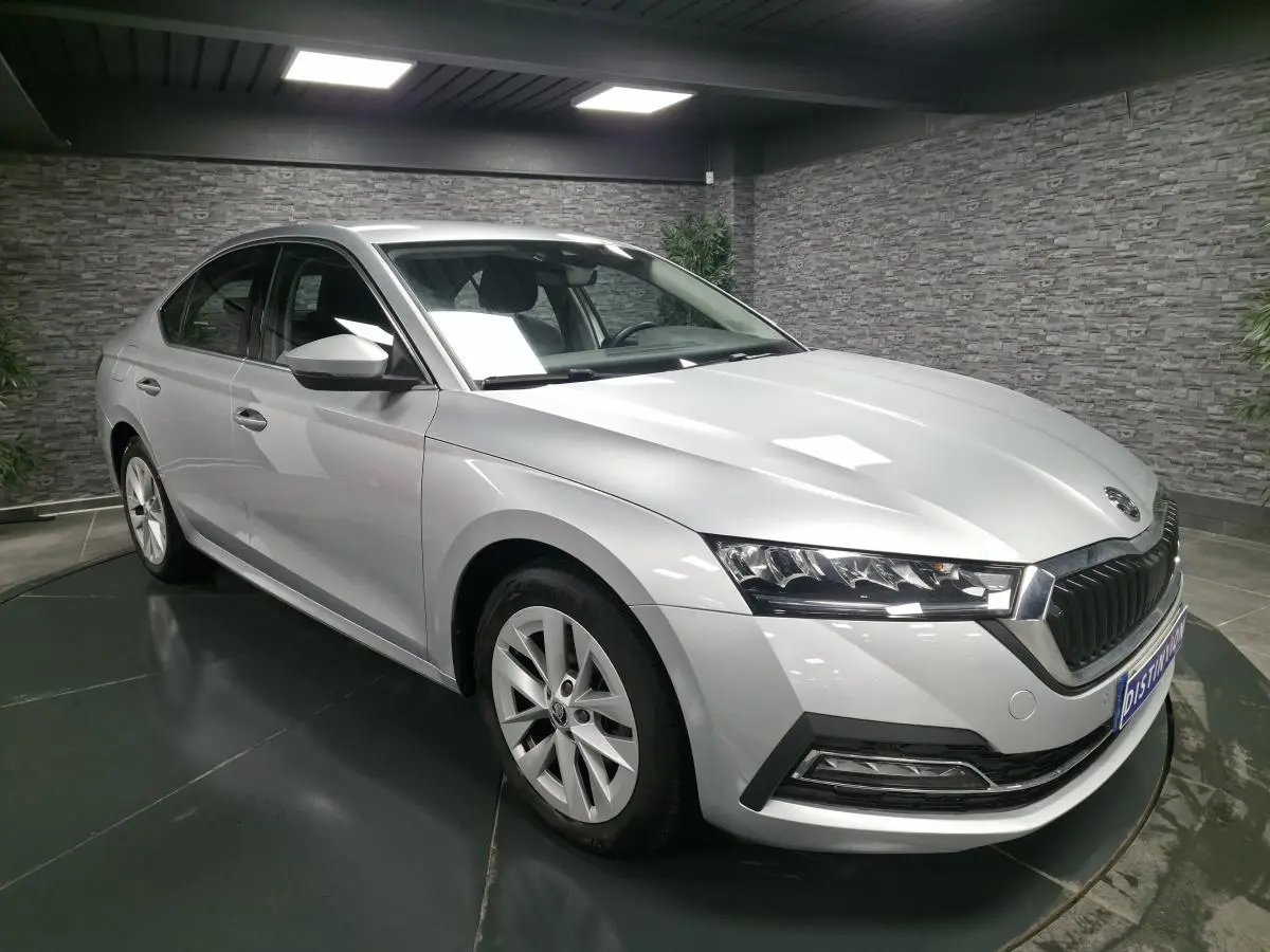 Vue 3/4 avant d'une Skoda Octavia gris métallisé 2023 avec jantes alliage 17 pouces dans un showroom intérieur.