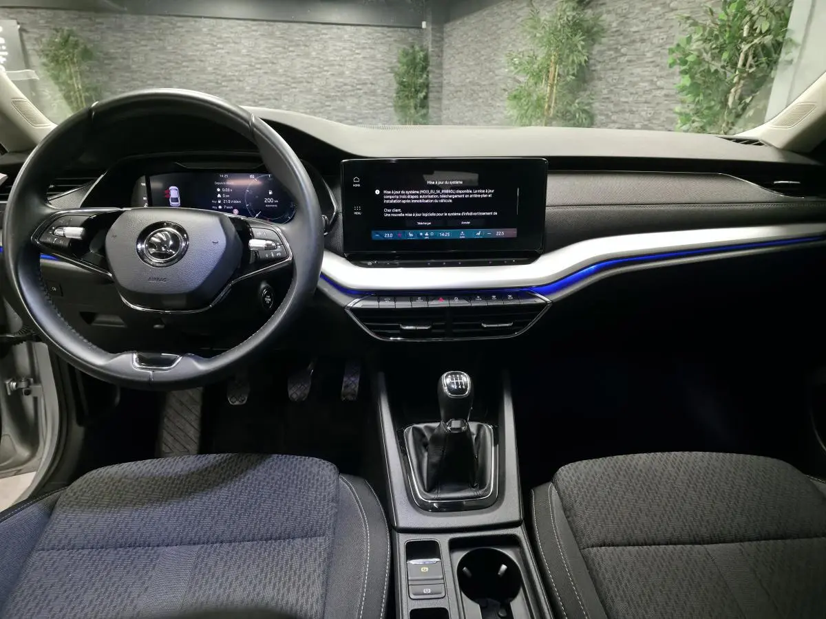 Intérieur de la Skoda Octavia 2023 vue de face, tableau de bord noir avec écran tactile et volant multifonctions.