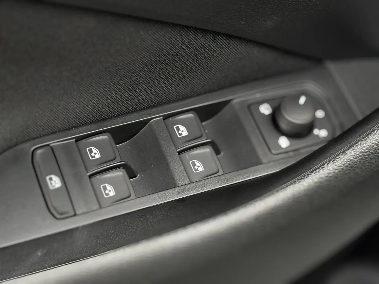 Gros plan sur les commandes des vitres et rétroviseurs côté conducteur du Skoda Kamiq gris argent 2025.