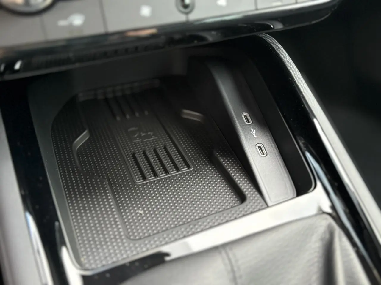 Gros plan sur le compartiment central avec chargeur induction et ports USB-C du Skoda Kamiq gris argent 2025.