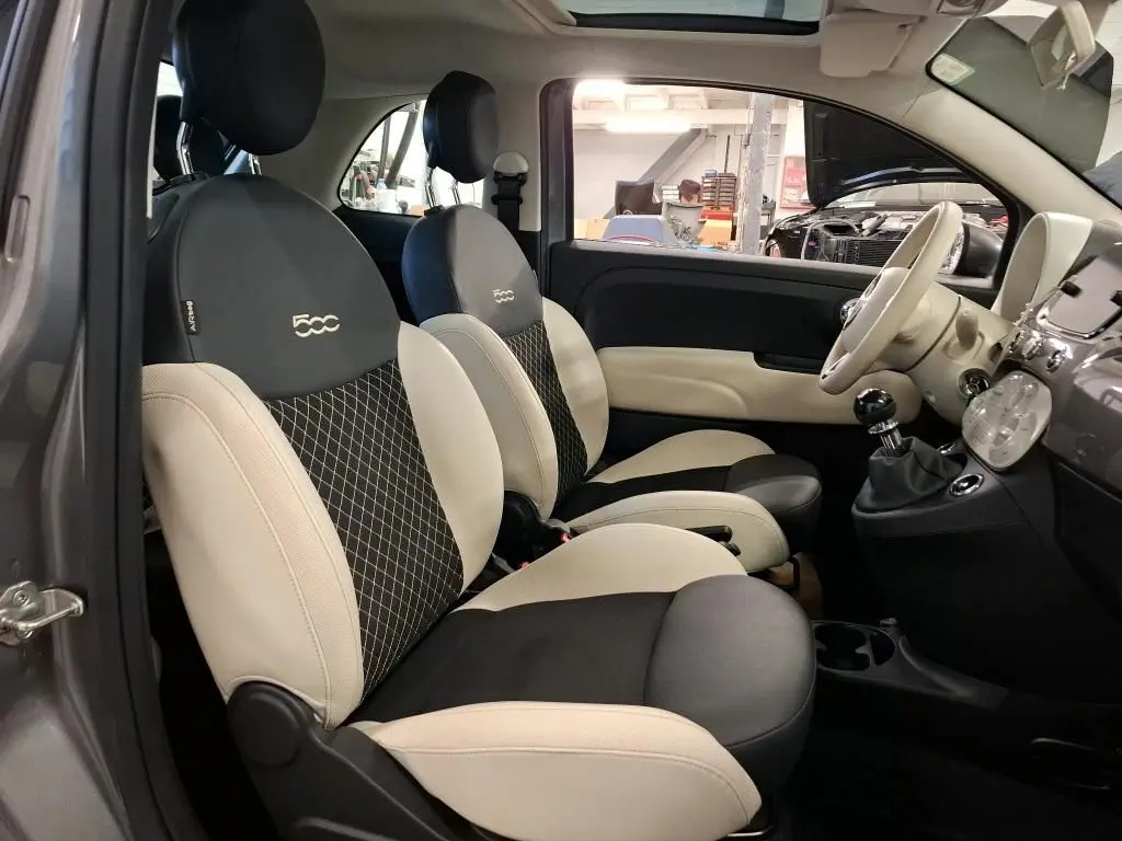 Vue intérieure côté gauche de la FIAT 500 2022 gris Electroclash, sièges bicolores avec logo 500 brodé sur appuie-tête.