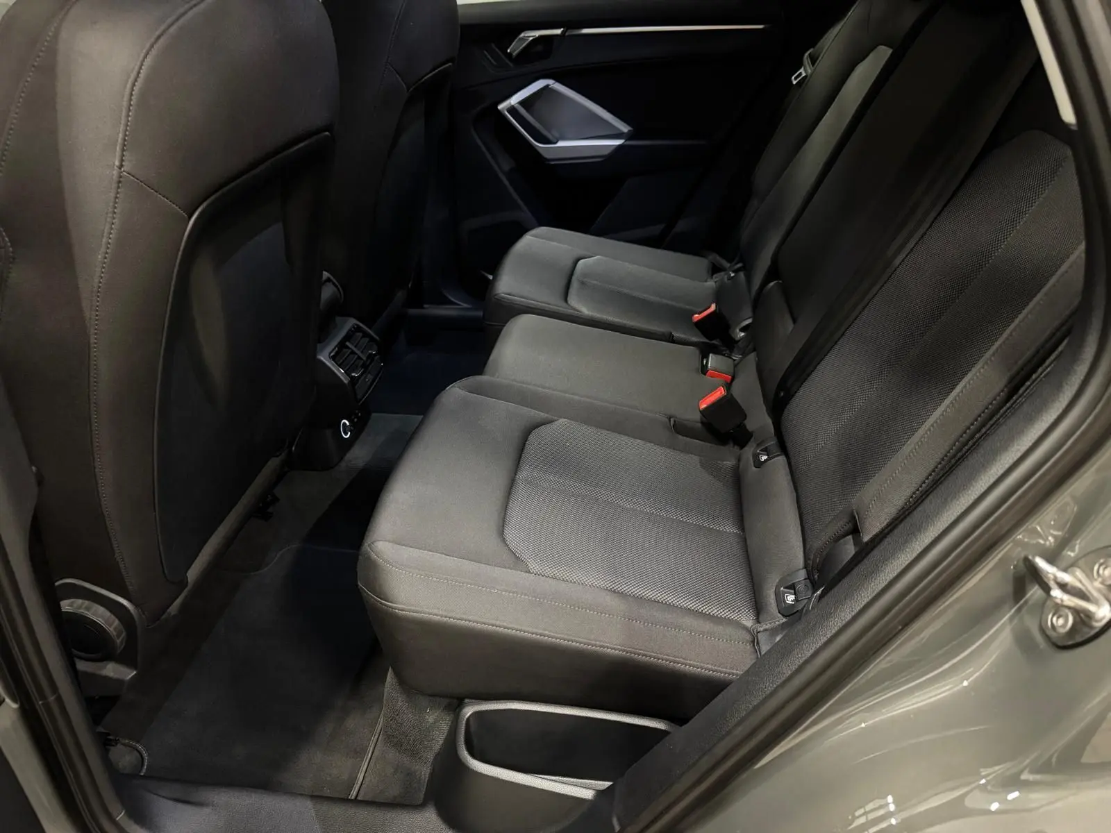 Vue côté droit de la banquette arrière en tissu gris foncé de l'Audi Q3 Business 2019 avec porte ouverte.